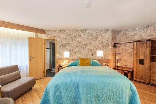 Hotel Berghof في باومهولدر: غرفة نوم بسرير كبير وأريكة
