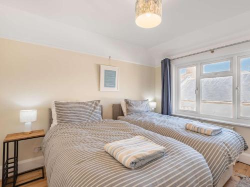 a bedroom with two beds and a window at 3 Bed in Swanage 84019 in Swanage