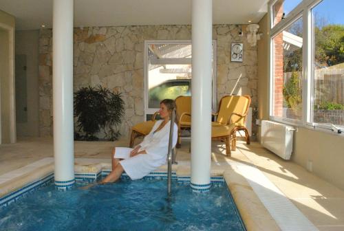 a woman sitting in a swimming pool at Carilo Soleil By HS in Carilo