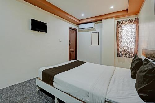 een slaapkamer met een groot bed en een raam bij OYO Sri Sai Sevalal Comfort's in Bangalore