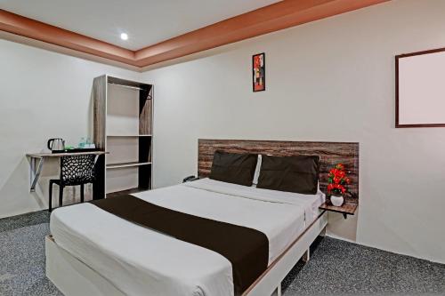 een slaapkamer met een groot bed en een bureau bij OYO Sri Sai Sevalal Comfort's in Bangalore