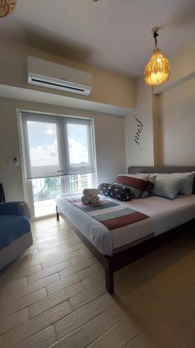 1 dormitorio con 1 cama grande y ventana grande en St. HONORE NEW Condo unit, en Iloilo City