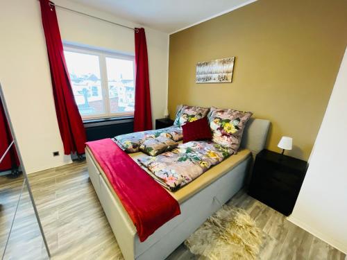 een kleine slaapkamer met een bed met rode gordijnen bij Ferienwohnung Michelangelo Stadtmitte "Netflix" in Eisenach