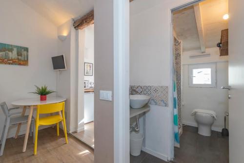 a small bathroom with a table and a yellow chair at I Host Apartment - Carcano 26 in Milan