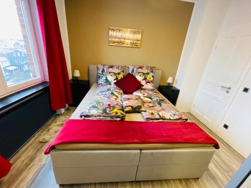 a bedroom with a bed with a red blanket at Pension Michelangelo Stadtmitte "Netflix" in Eisenach