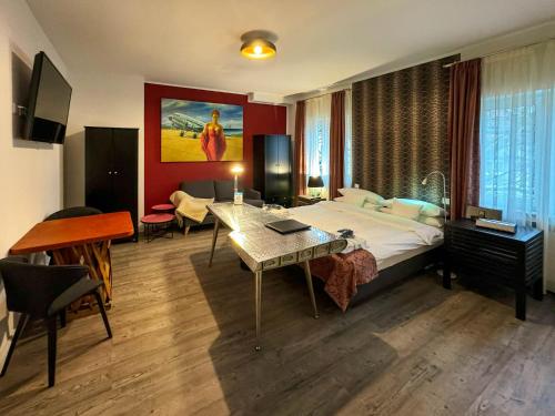 エッセンにあるTrip Inn Boutique Rubensのベッド、デスク、ピアノが備わるホテルルームです。