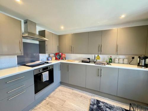 a kitchen with white cabinets and a stove at Blakes Beach House Humberston Fitties in Humberston