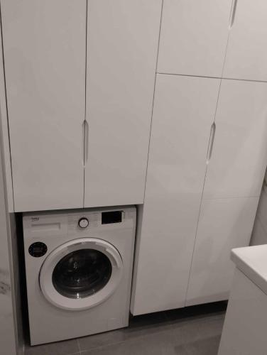 a washing machine in a kitchen with white cabinets at Σπίτι για 4 άτομα στα Κάτω Πατήσια in Athens
