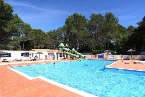 - une piscine avec un toboggan au milieu dans l'établissement Les Grands Pins emplacement numéro 103, au Castellet