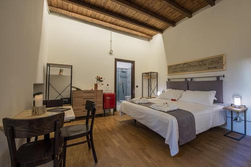 a bedroom with a large bed and a table and chairs at Locanda Leonardo Hotel in Calolziocorte