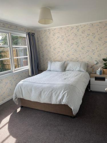 a bedroom with a large bed and a window at Stay@10 in Blenheim