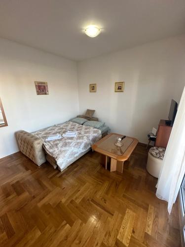 ポドゴリツァにあるApartment Stex 4のベッドとテーブルのある寝室