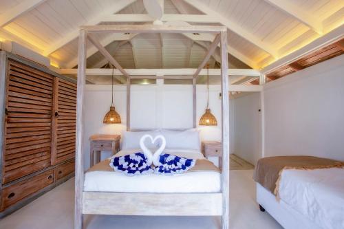 a bedroom with a four poster bed in a room at Aloha 7 in Ponta Mamoli