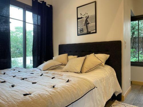 un grand lit dans une chambre avec une fenêtre dans l'établissement Moulleau - charmante maison 4 chambres et jardin privé, à La Teste-de-Buch