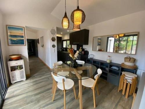une cuisine et une salle à manger avec une table et des chaises en verre dans l'établissement Moulleau - charmante maison 4 chambres et jardin privé, à La Teste-de-Buch