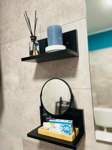 a mirror on a shelf in a bathroom at Pension Michelangelo Stadtmitte "Netflix" in Eisenach