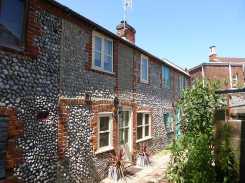 5 Museum Cottages في شيرينغهام: مبنى من الطوب عليه نوافذ بيضاء