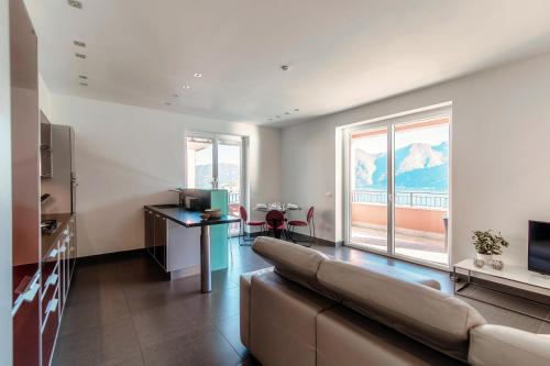 a living room with a couch and a large window at Rosso Sunset - by MyHomeInComo in Colonno