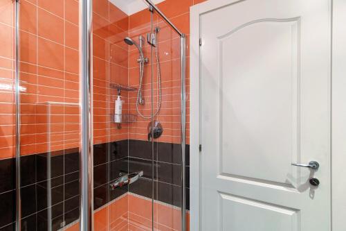 a shower in a bathroom with orange tile at Rosso Sunset - by MyHomeInComo in Colonno