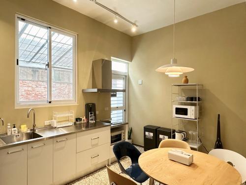 a kitchen with a table and a sink and a table and a table at 衛民居 wei min stay in Tainan