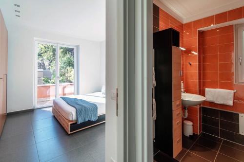 a bedroom with a bed and a bathroom with a sink at Rosso Sunset - by MyHomeInComo in Colonno