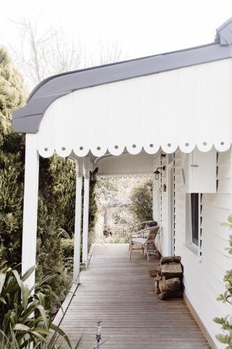a white pergola on a porch of a house at MARIGOLD COTTAGE Charming 1870s central Daylesford cottage in Daylesford