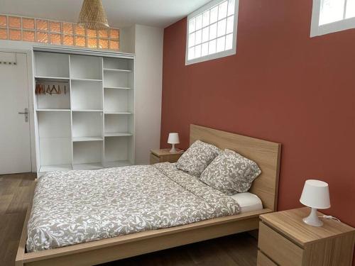 - une chambre avec un lit et un mur avec des étagères dans l'établissement Le Terracota, à Boulogne-sur-Mer