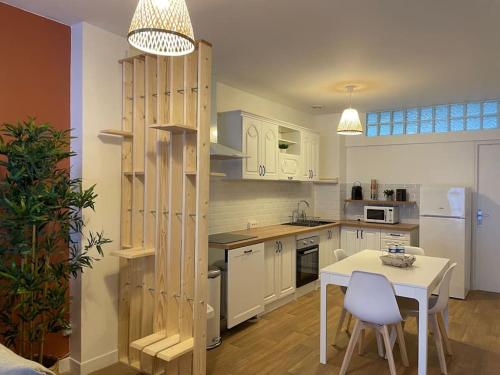 - une cuisine avec une table blanche et une étagère en bois dans l'établissement Le Terracota, à Boulogne-sur-Mer