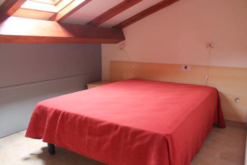 - une chambre avec un lit rouge et une couverture rouge dans l'établissement Appartamento con 2 camere da letto a 200 m dalla spiaggia, à Linguizzetta
