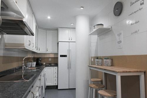 a kitchen with white cabinets and a white refrigerator at MonKeys Apartments Lumbreras Deluxe in Seville