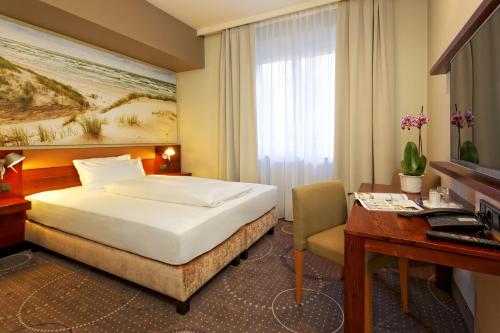 a hotel room with a bed and a desk at Hotel Kaliebe in Trassenheide