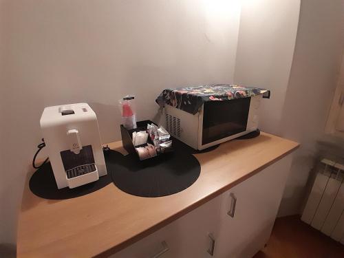 a desk with a microwave and a computer on it at appartamento Martina, silenzioso a 100 metri dalla metropolitana in Milan