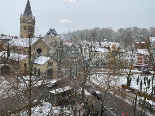 a snow covered city with a church and a tower at Pension Michelangelo Stadtmitte "Netflix" in Eisenach