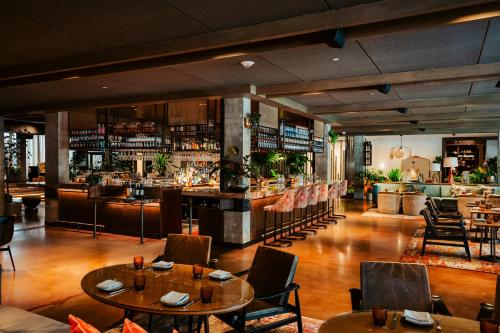 a restaurant with tables and chairs and a bar at Vignette Collection Yours Truly DC by IHG in Washington