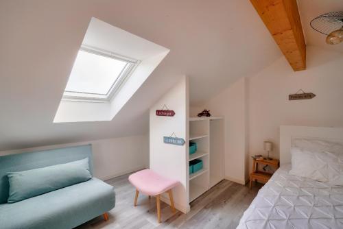 une chambre mansardée avec un lit et une fenêtre dans l'établissement Duplex pour 6 - 100m de la plage de Pors Carn, à Penmarcʼh