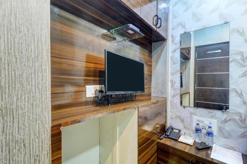 a room with a tv on a wooden wall at Hotel Shabana - Colaba Causeway in Mumbai