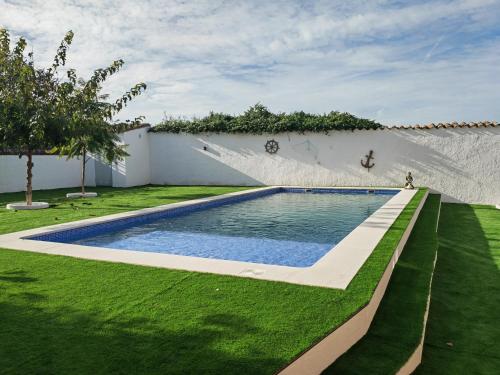 una piscina en un patio con césped verde en Casa Rural Teralba, en La Calzada de Oropesa