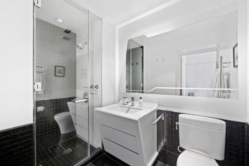 a bathroom with a sink and a toilet and a mirror at Financial District studio w WD gym elevator NYC-1359 in New York