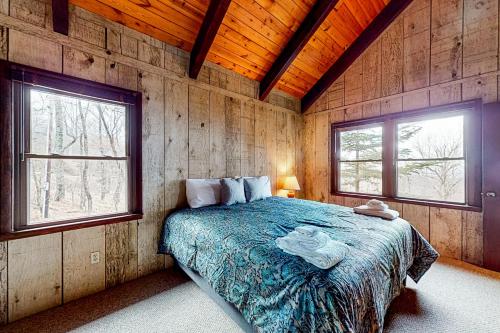 ein Schlafzimmer mit einem Bett in einem Zimmer mit zwei Fenstern in der Unterkunft The Treasure of Beech Mountain in Beech Mountain