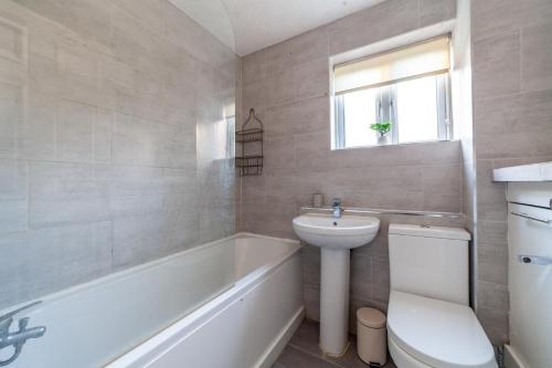 uma casa de banho com um lavatório, um WC e uma banheira em The Walthamstow Collection em Londres