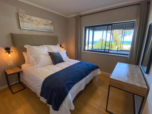 Un dormitorio con una cama grande y una ventana en Sundrenched 2 bed 2 bath apartment + sea views en Ciudad del Cabo