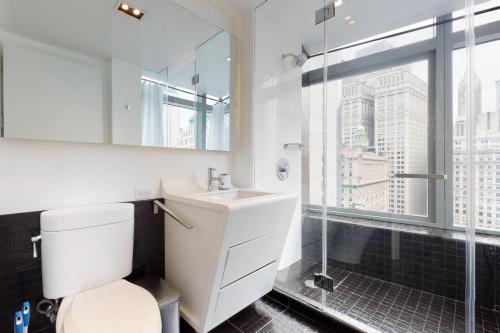 Financial District 1br w WD gym elevator NYC-1369 في نيويورك: حمام مع مرحاض ومغسلة ودش