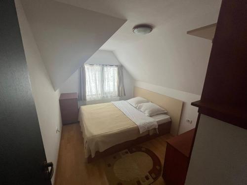 um pequeno quarto com uma cama e uma janela em Pensiunea Valea Dorului em Fundstica