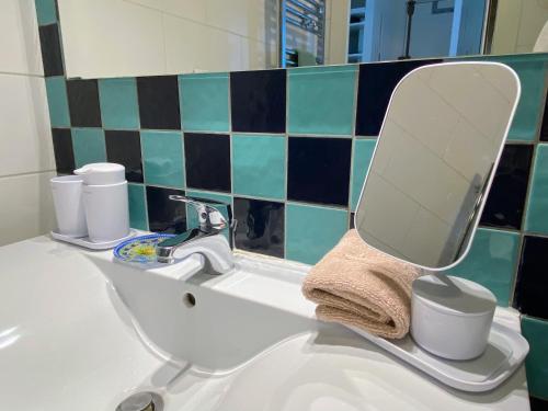 La salle de bains est pourvue d'un lavabo et d'un miroir. dans l'établissement Les Beaux Jours - Calm & Sunny balcony, à Antibes