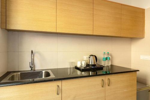 Una cocina con fregadero y armarios de madera. en Pine Maderas by Embrace, en Kasauli