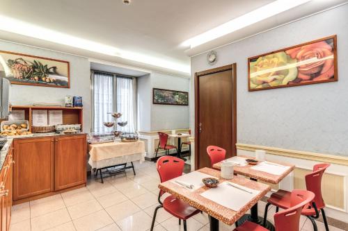 a dining room with tables and chairs and a kitchen at Hotel Milo in Rome