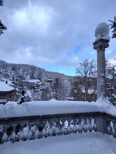 a fence covered in snow with a light pole at Park Hotel Amfora -Free Parking in Sofia