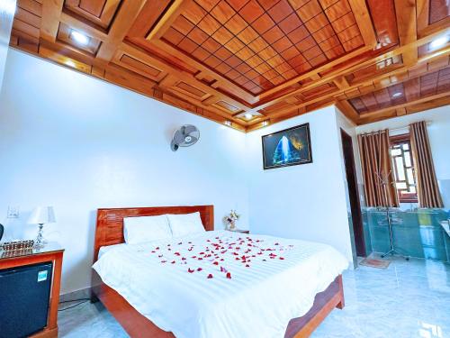 a bedroom with a bed with red flowers on it at The Hill Villas in Phong Nha