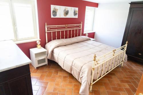 Alloggio turistico Il Tiglio في كانالي مونتيرانو: غرفة نوم بسرير في جدار احمر