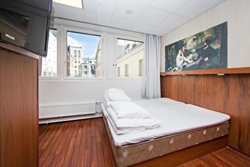 Habitación pequeña con cama y ventana en Omena Hotel Helsinki City Centre, en Helsinki